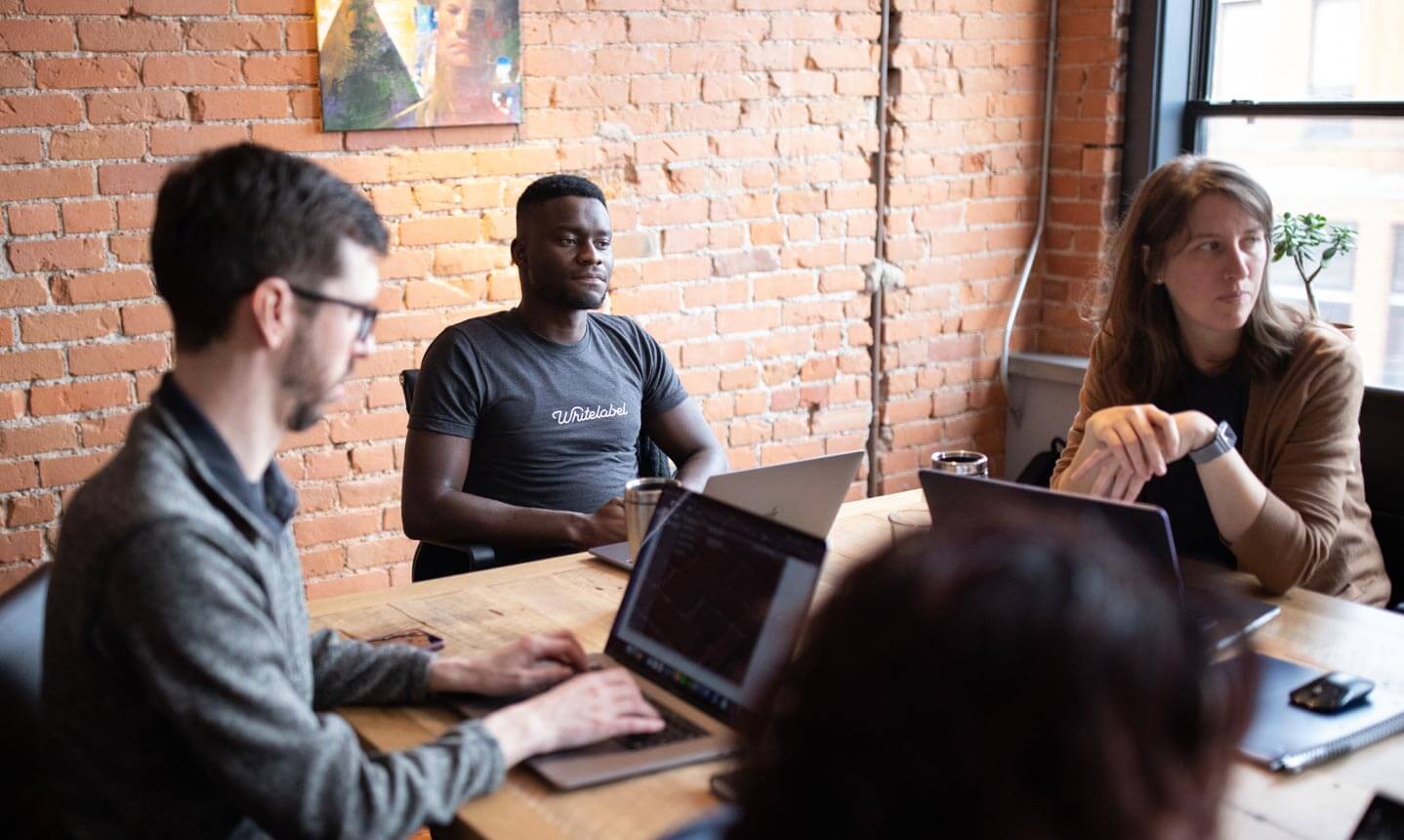 a group of devs at work sitting at conference table discussing strategy